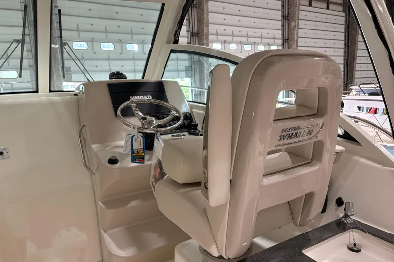 Slide: The Image of Interior of 2026 Boston Whaler 285 Conquest boat with steering wheel and captain's chair. - 14
