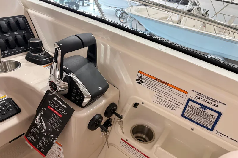 Slide: The Image of 2026 Boston Whaler 285 Conquest cockpit controls with dual handle ERC and warning labels. - 15