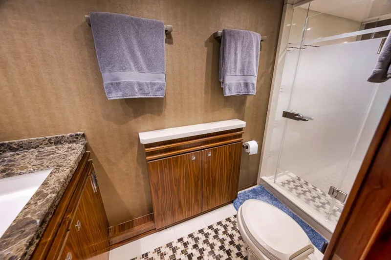 Slide: The Image of Luxurious bathroom in 2018 Viking 92 Sky Bridge yacht with elegant wood cabinetry and modern shower. - 106