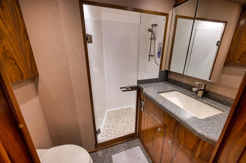 Slide: The Image of Luxurious bathroom in 2018 Viking 92 Sky Bridge yacht with modern fixtures and wood accents. - 113