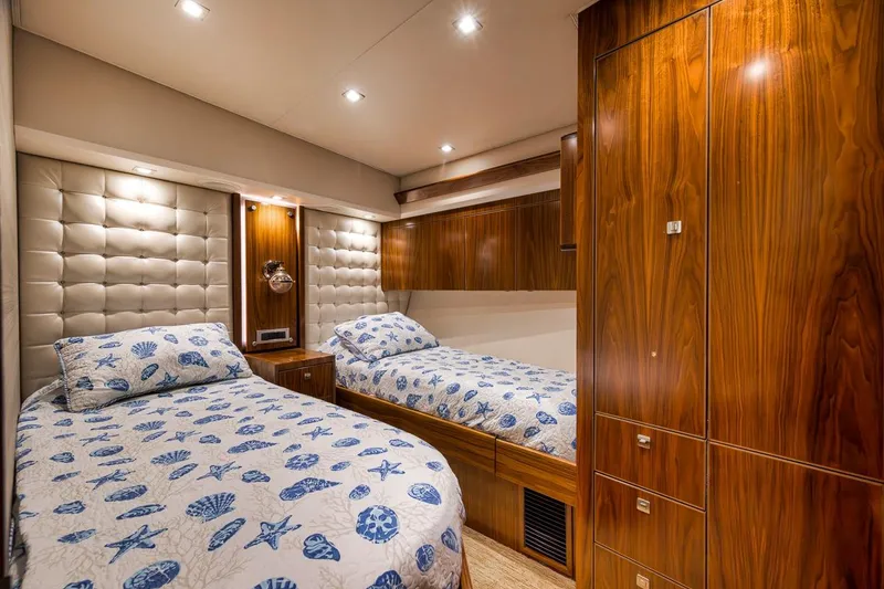Slide: The Image of Luxurious cabin interior of 2018 Viking 92 Sky Bridge yacht with twin beds and wood paneling. - 114