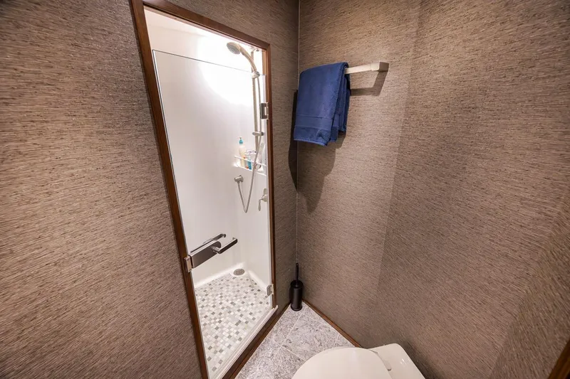 Slide: The Image of Luxurious bathroom in 2018 Viking 92 Sky Bridge yacht with shower and towel rack. - 119