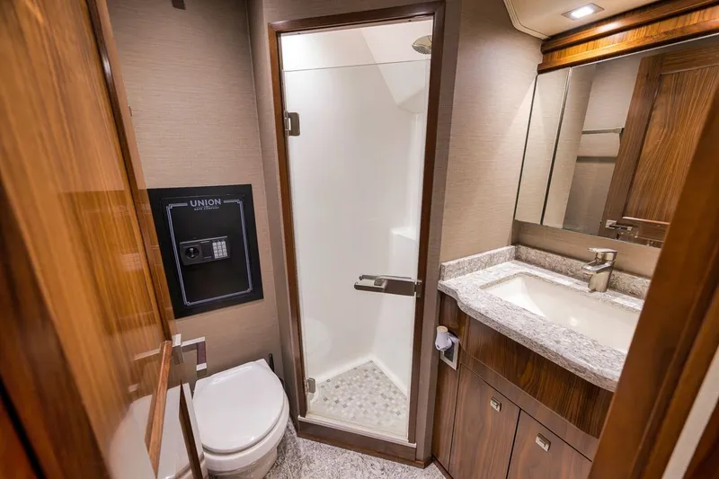Slide: The Image of Luxurious bathroom in 2018 Viking 92 Sky Bridge yacht with shower, sink, and safe. - 121