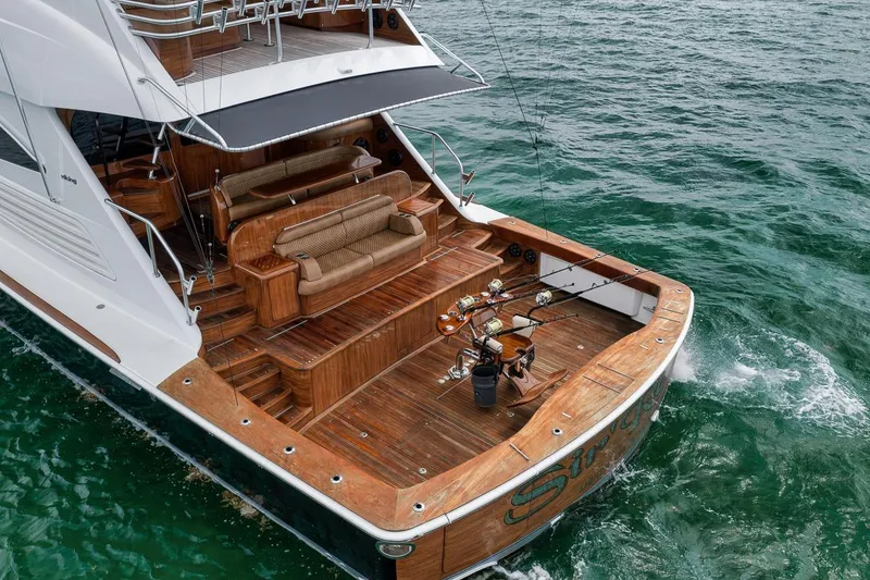 Slide: The Image of Luxury 2018 Viking 92 Sky Bridge yacht with spacious wooden deck and fishing gear. - 19