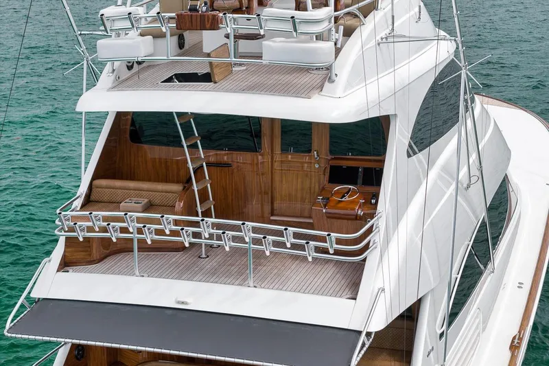 Slide: The Image of 2018 Viking 92 Sky Bridge yacht with elegant deck and seating, cruising on clear waters. - 22