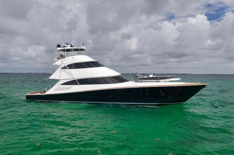 Slide: The Image of 2018 Viking 92 Sky Bridge yacht on turquoise water under cloudy sky. - 4