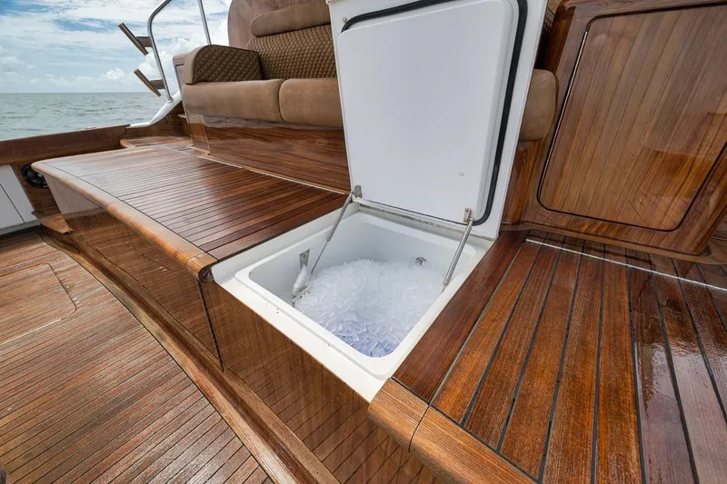 Slide: The Image of Luxurious 2018 Viking 92 Sky Bridge yacht with open ice chest on polished wooden deck. - 45