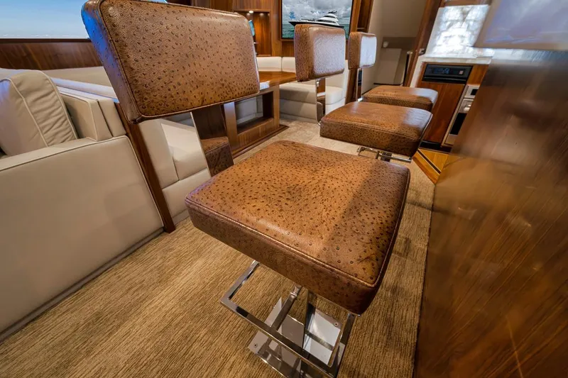 Slide: The Image of Luxurious interior of 2018 Viking 92 Sky Bridge yacht with elegant leather bar stools. - 84