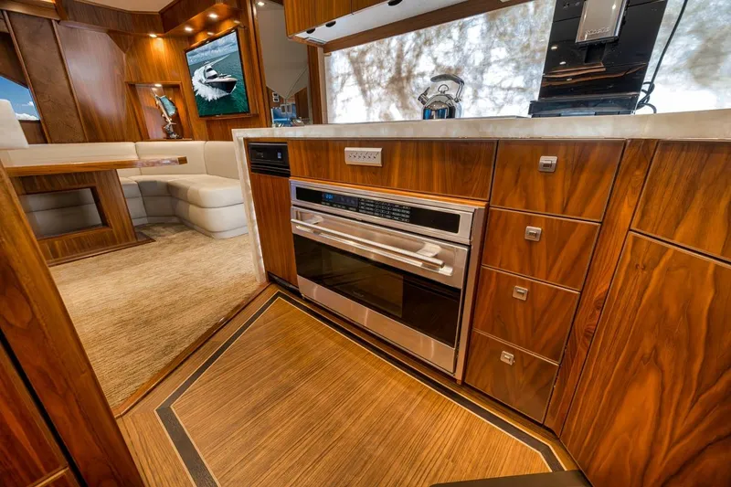 Slide: The Image of Luxurious interior of 2018 Viking 92 Sky Bridge yacht with modern kitchen and seating area. - 92