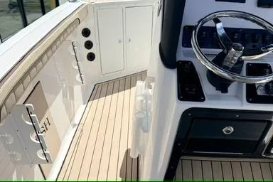 Slide: The Image of 2025 Yamaha Boats 222 FSH Sport E cockpit with steering wheel and storage compartments. - 17