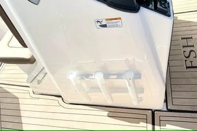 Slide: The Image of 2025 Yamaha Boats 222 FSH Sport E deck with rod holders and FSH branding. - 18