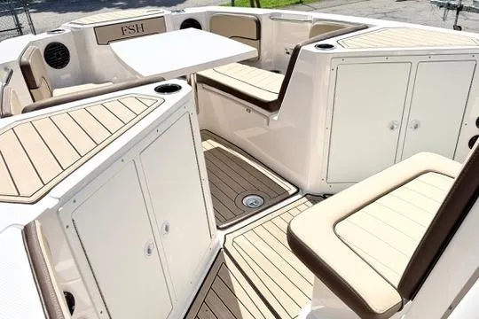 Slide: The Image of 2025 Yamaha Boats 222 FSH Sport E interior with seating and storage compartments. - 19