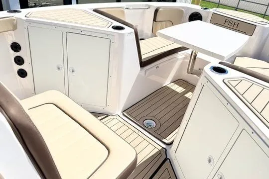 Slide: The Image of 2025 Yamaha Boats 222 FSH Sport E interior with seating and table, featuring sleek design. - 20