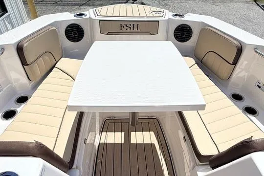 Slide: The Image of 2025 Yamaha Boats 222 FSH Sport E interior with beige seating and table setup. - 25