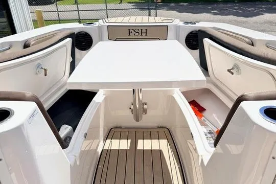 Slide: The Image of 2025 Yamaha Boats 222 FSH Sport E interior with storage compartments and table. - 30
