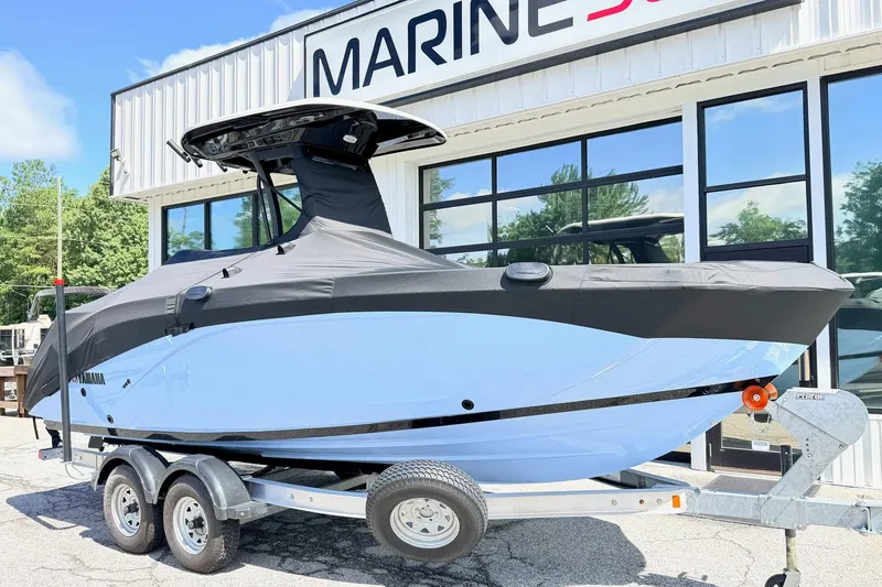Slide: The Image of 2025 Yamaha Boats 222 FSH Sport E on trailer, covered, outside Marine dealership. - 5