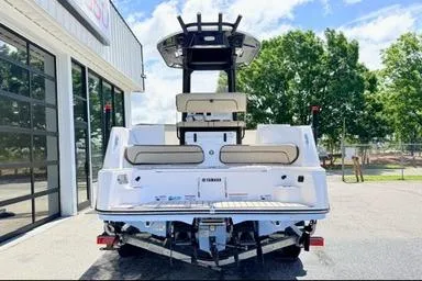 Slide: The Image of 2025 Yamaha Boats 222 FSH Sport E, rear view, parked outdoors near a building. - 6