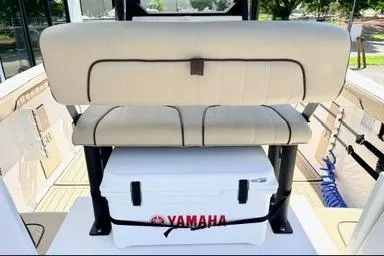 Slide: The Image of 2025 Yamaha Boats 222 FSH Sport E interior with seating and cooler. - 8