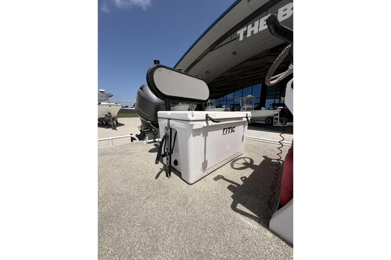 Slide: The Image of Outdoor scene with RTIC cooler beside Custom Battersea boat, 2017 model, under clear blue sky. - 11