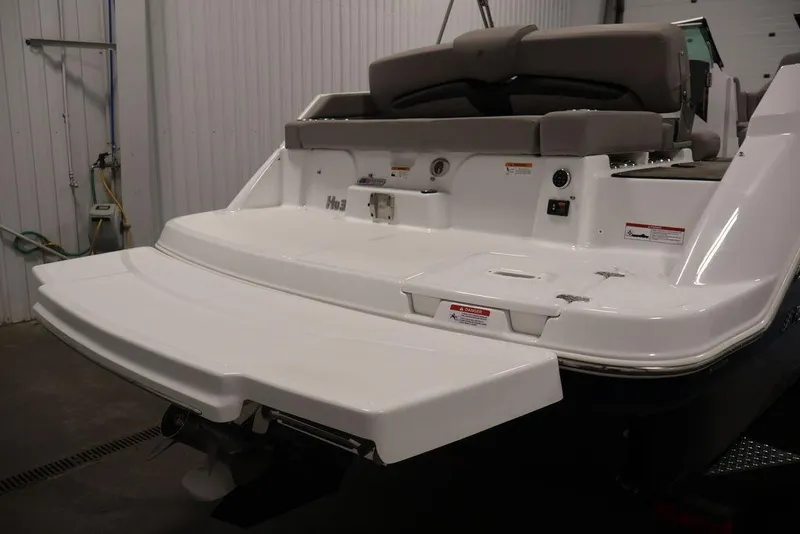 Slide: The Image of 2026 Four Winns HD3 boat stern view with swim platform in a garage setting. - 10