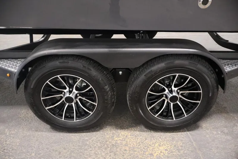 Slide: The Image of Trailer wheels of a 2026 Four Winns HD3 boat, featuring sleek black rims. - 12