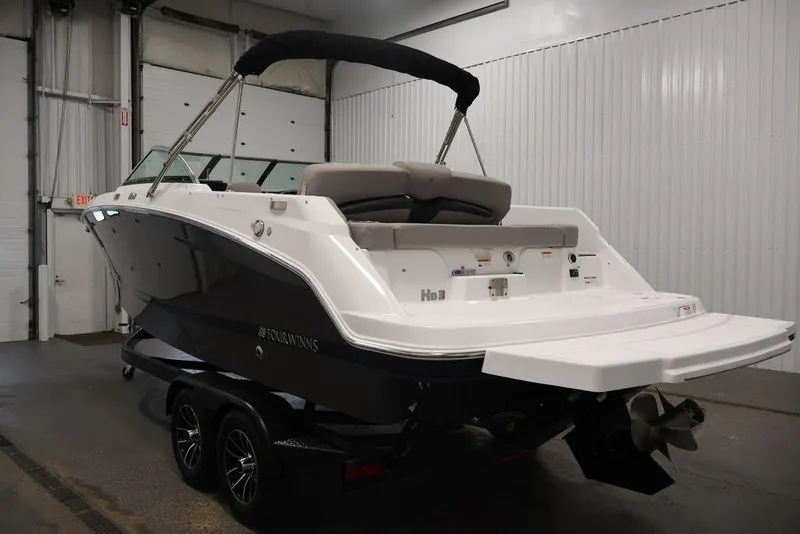 Slide: The Image of 2026 Four Winns HD3 boat in a showroom, featuring sleek design and dual-axle trailer. - 36