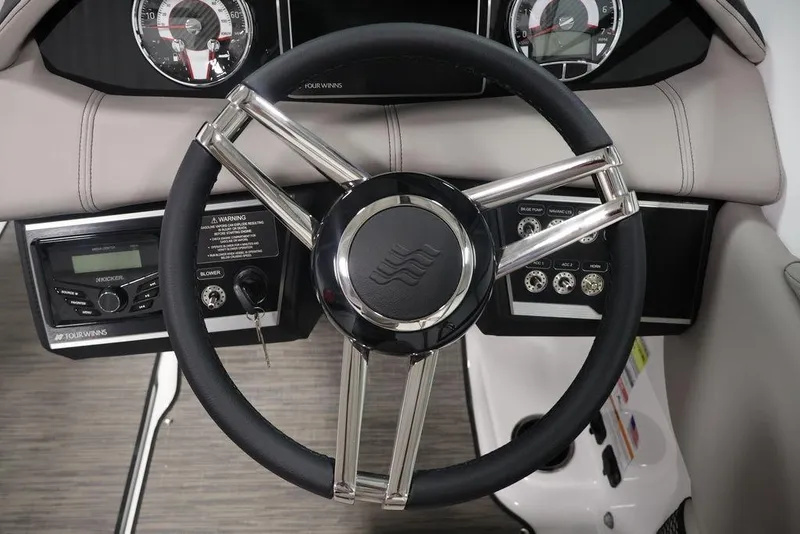 Slide: The Image of Steering wheel and dashboard of 2026 Four Winns HD3 boat, featuring modern controls and gauges. - 4