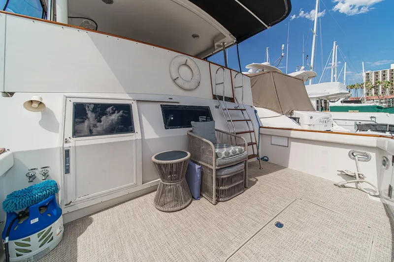 Slide: The Image of 1991 Californian 55 Cockpit Motor Yacht deck with seating, ladder, and marina view. - 11