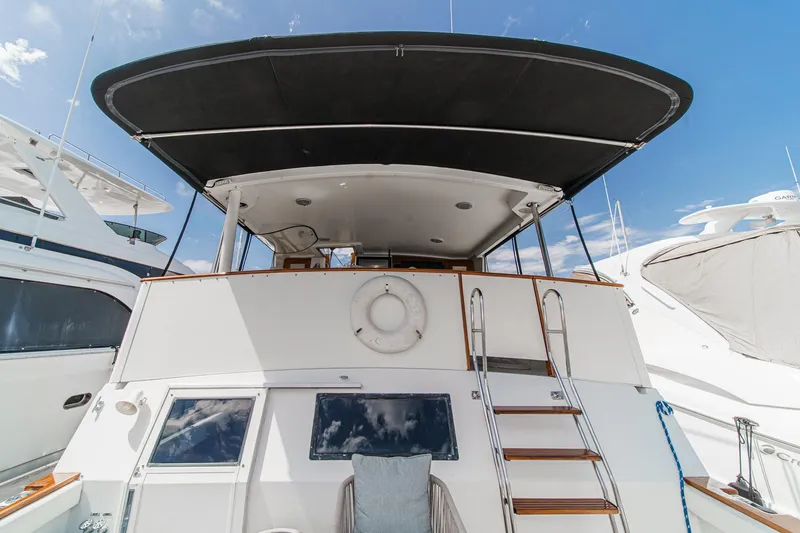 Slide: The Image of 1991 Californian 55 Cockpit Motor Yacht with ladder and canopy, docked under clear sky. - 12