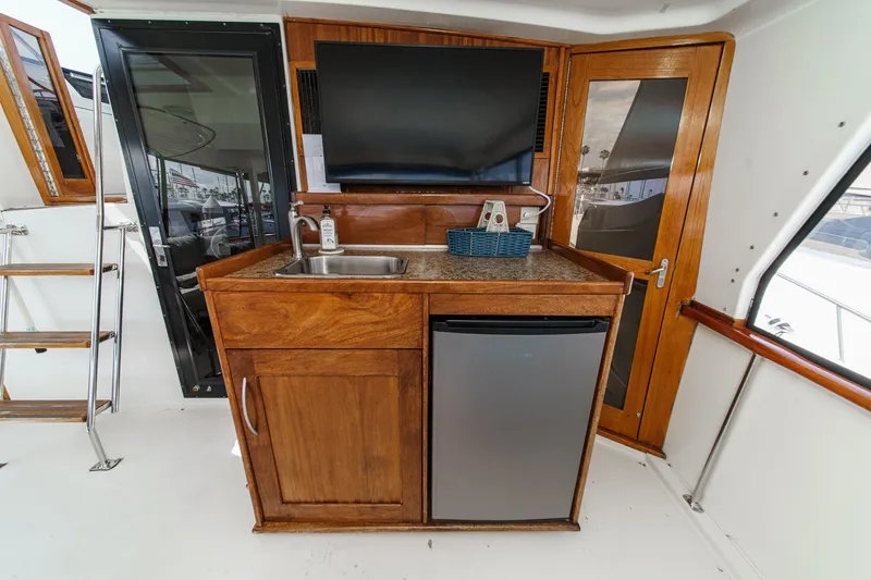 Slide: The Image of 1991 Californian 55 Cockpit Motor Yacht interior with kitchenette, sink, and mini fridge. - 17