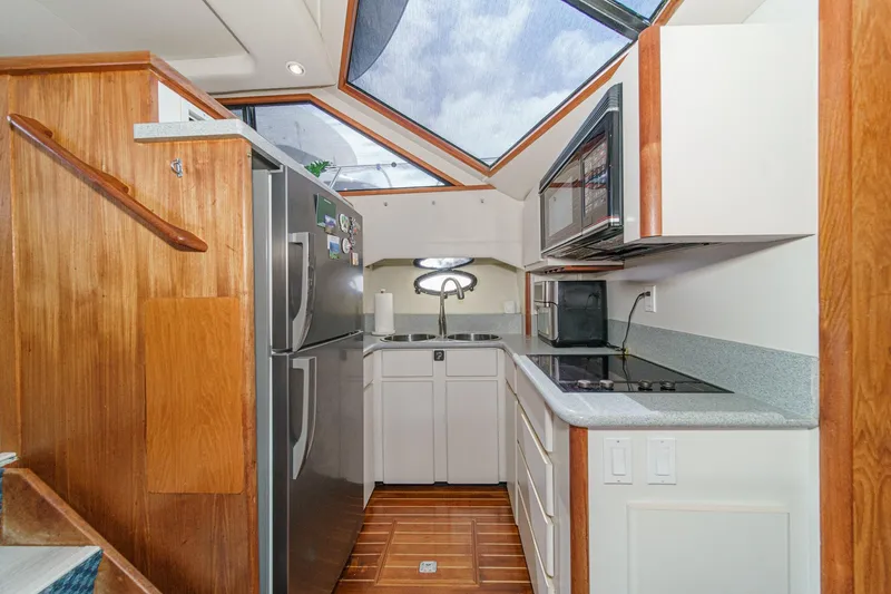 Slide: The Image of Modern kitchen interior of 1991 Californian 55 Cockpit Motor Yacht with skylight and wood accents. - 27