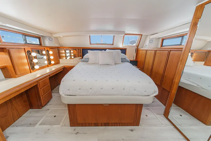 Slide: The Image of Luxurious 1991 Californian 55 Cockpit Motor Yacht bedroom with elegant wood finishes and ample lighting. - 37
