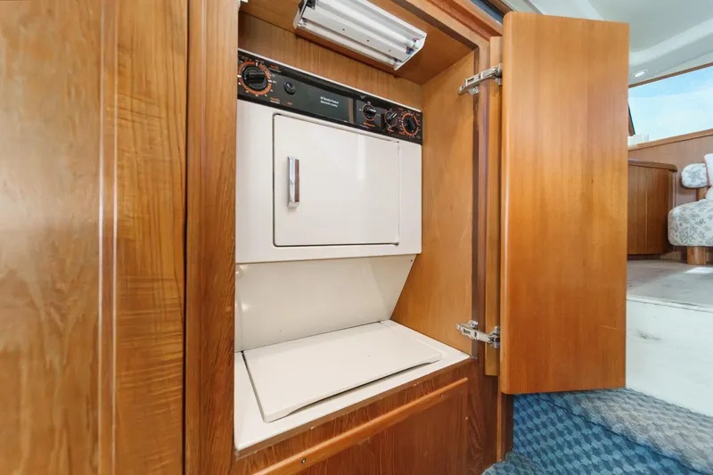 Slide: The Image of Laundry unit inside 1991 Californian 55 Cockpit Motor Yacht, wooden cabinetry, blue carpet. - 44