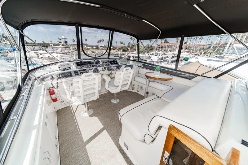 Slide: The Image of 1991 Californian 55 Cockpit Motor Yacht interior with helm, seating, and marina view. - 46