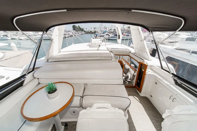Slide: The Image of Luxurious 1991 Californian 55 Cockpit Motor Yacht interior with seating and table, docked at marina. - 50