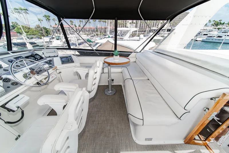 Slide: The Image of 1991 Californian 55 Cockpit Motor Yacht interior with helm, seating, and marina view. - 51