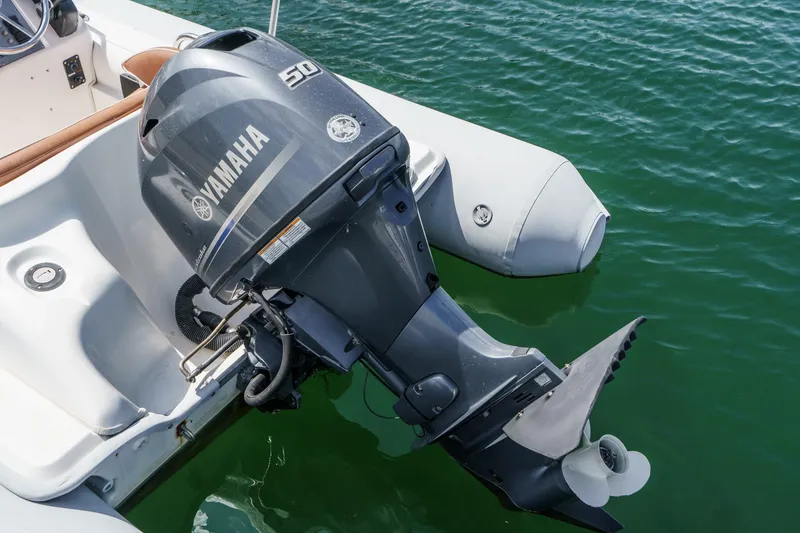 Slide: The Image of Yamaha 50 outboard motor on a 1991 Californian 55 Cockpit Motor Yacht, docked in green water. - 62