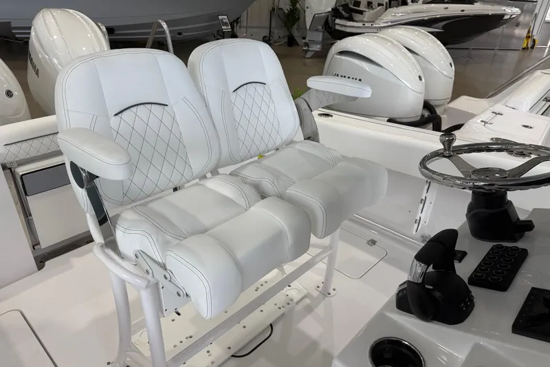 Slide: The Image of 2026 Sportsman Open 252 Center Console boat with dual white cushioned seats and steering wheel. - 11