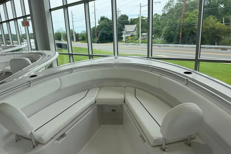 Slide: The Image of 2026 Sportsman Open 252 Center Console boat interior with white seating in showroom. - 4