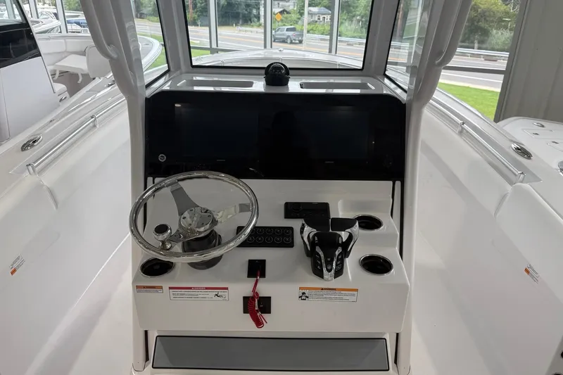 Slide: The Image of 2026 Sportsman Open 252 Center Console boat interior with steering wheel and control panel. - 8
