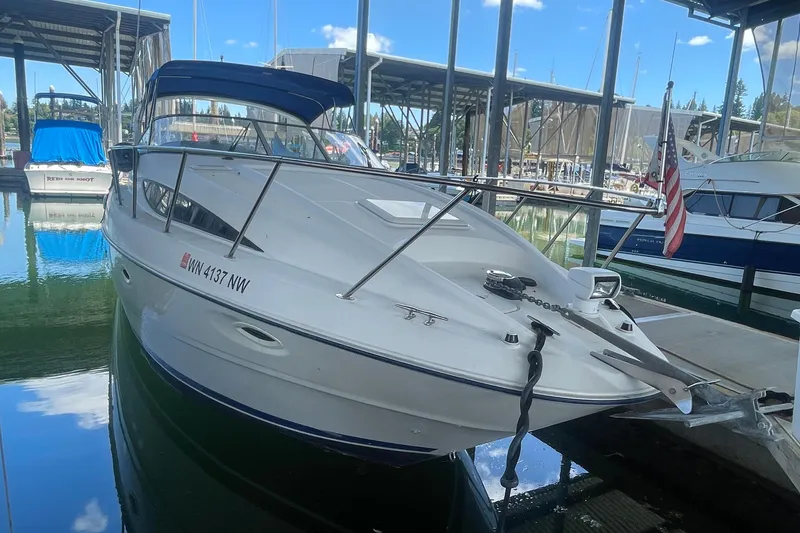Slide: The Image of 2006 Bayliner 305 boat docked in a marina under a clear blue sky. - 1