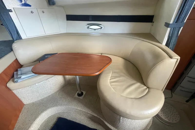Slide: The Image of Interior of a 2006 Bayliner 305 boat with beige seating and wooden table. - 15