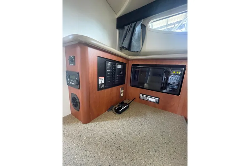 Slide: The Image of 2006 Bayliner 305 interior with control panel and microwave in cabin. - 21