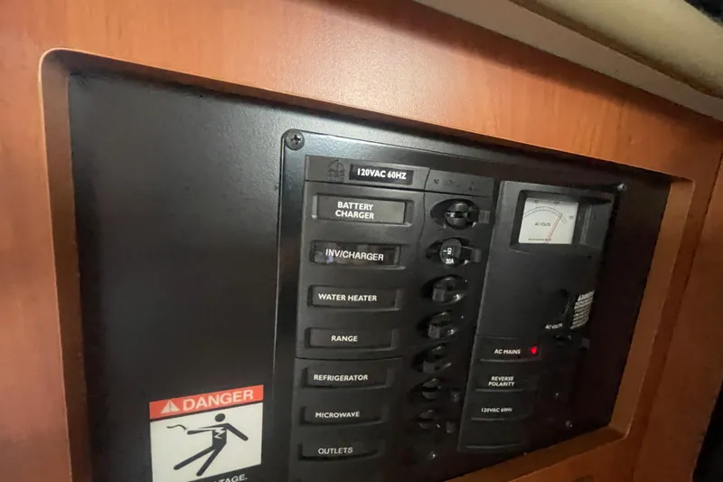 Slide: The Image of Electrical control panel in a 2006 Bayliner 305 boat, featuring various switches and a voltage meter. - 23