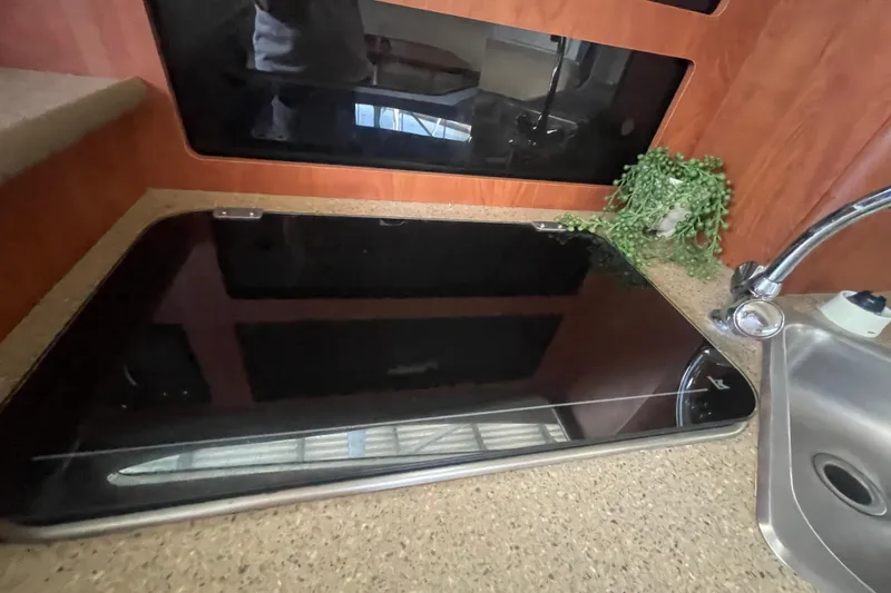 Slide: The Image of Interior of 2006 Bayliner 305 boat with sleek countertop and sink area. - 25
