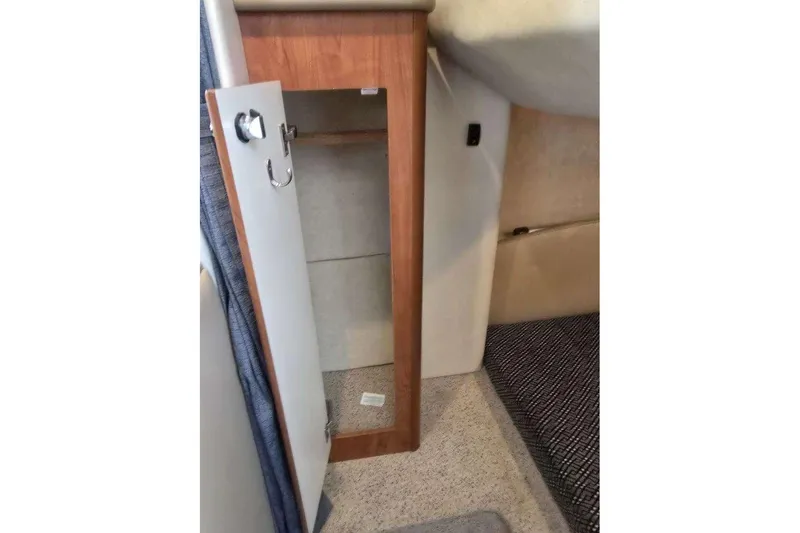Slide: The Image of Open wooden cabinet inside 2006 Bayliner 305 boat interior. - 31