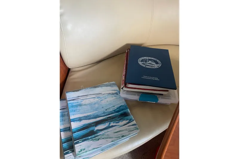 Slide: The Image of Books and folders on a beige leather seat in a 2006 Bayliner 305 boat. - 38