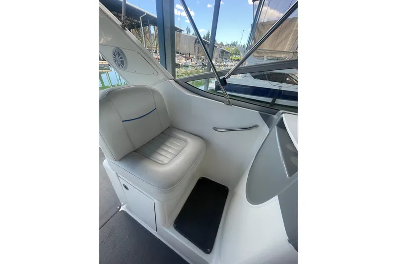 Slide: The Image of 2006 Bayliner 305 boat interior with white seating and window view. - 4