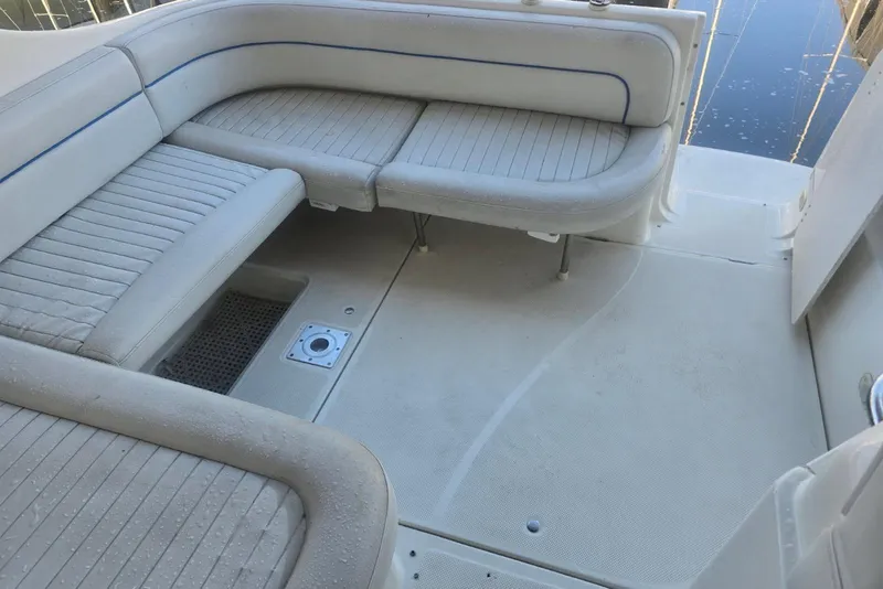 Slide: The Image of 2006 Bayliner 305 boat interior with white cushioned seating and clean deck. - 6