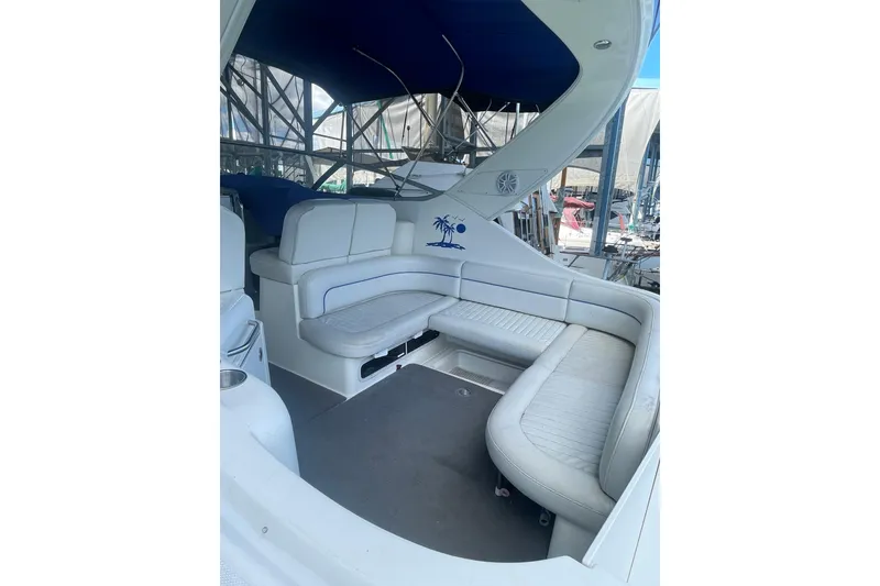 Slide: The Image of 2006 Bayliner 305 boat interior with white seating and blue canopy. - 8